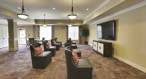 a large living room with chairs and a television